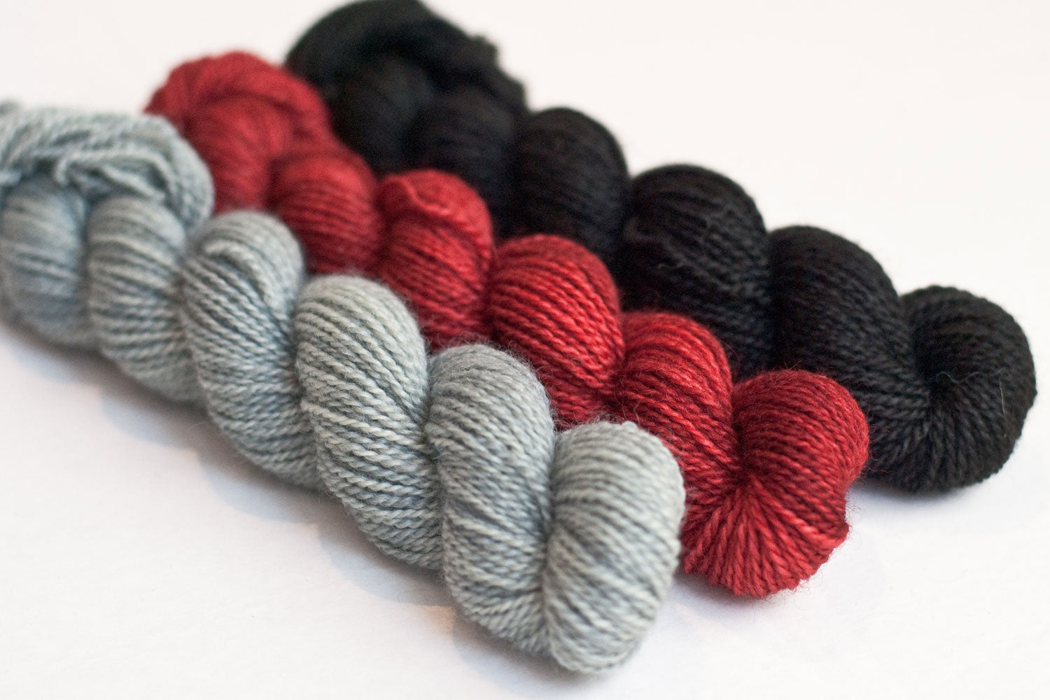 Dark gnome yarn set of three mini-skeins in grey, red and black, for gnomei mystery knitalong 9 with Imagined Landscapes