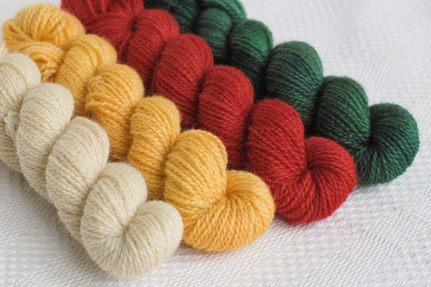 Set of four hand-dyed mini-skeins in natural, yellow, red, and green